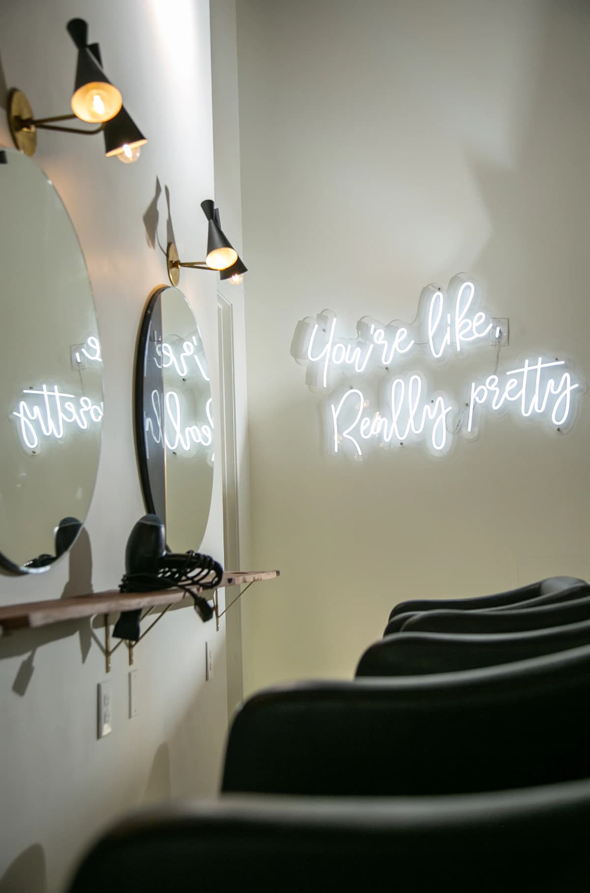 Salon chairs beside illuminated mirrors